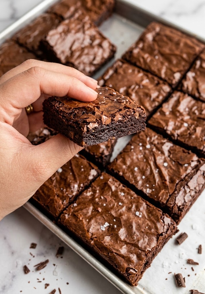 Mão segurando um pedaço de brownie